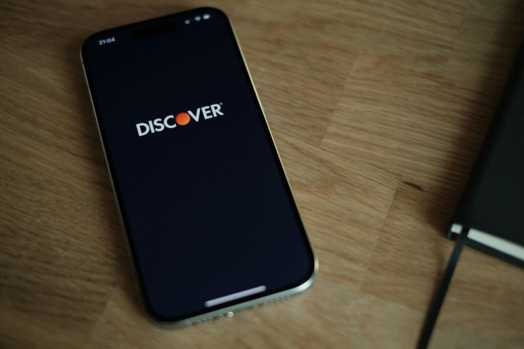 Ein Smartphone liegt auf einem hölzernen Tisch. Klare Sicht auf das Gerät und die Maserung des Holzes im Hintergrund.
