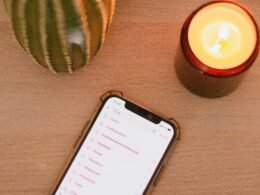 Ein Smartphone befindet sich auf einem hölzernen Tisch – moderne Technologie auf klassischer Oberfläche.