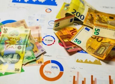 Einige Geldscheine liegen ordentlich auf einer Holzoberfläche und zeigen verschiedene Währungen.