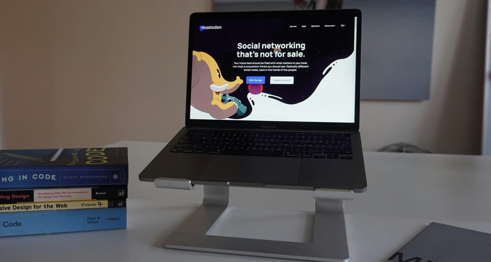 Ein moderner Laptop steht offen auf einem weißen Schreibtisch neben Zubehör, bereit für den Arbeitstag.