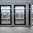 Leere Bahnsteighalle mit zwei geöffneten Türen, modernes Design und klare Linien, geeignet für Themen rund um Mobilität und Infrastruktur