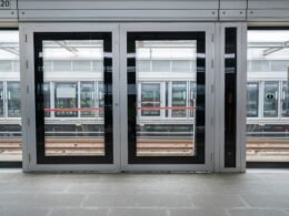 Leere Bahnsteighalle mit zwei geöffneten Türen, modernes Design und klare Linien, geeignet für Themen rund um Mobilität und Infrastruktur