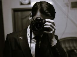 Ein Mann nimmt mit einer modernen Kamera ein Bild auf. Geeignet für Beiträge zu Fotografie oder Technik.