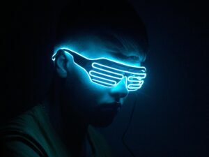 Mann mit leuchtender Neonmaske im dunklen Hintergrund als Sinnbild moderner Technologie und Anonymität