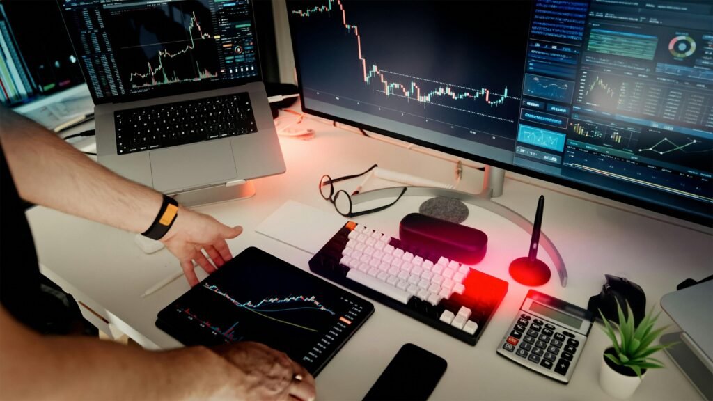 Ein Mann sitzt an einem Schreibtisch mit zwei Monitoren und einem Laptop, ideale Umgebung für digitales Arbeiten.