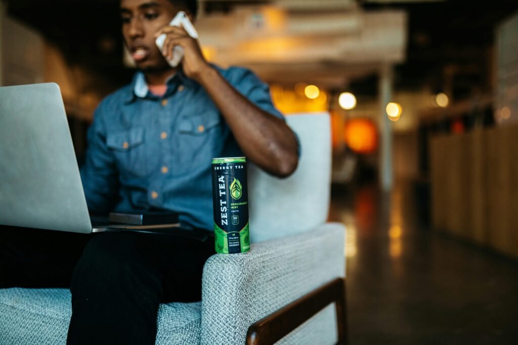 Mann sitzt in einem Sessel und spricht am Handy, alltägliche mobile Kommunikation in einem modernen Setting