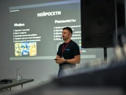 Ein Mann hält eine Präsentation vor einer großen Projektor-Leinwand in einem modernen Raum.