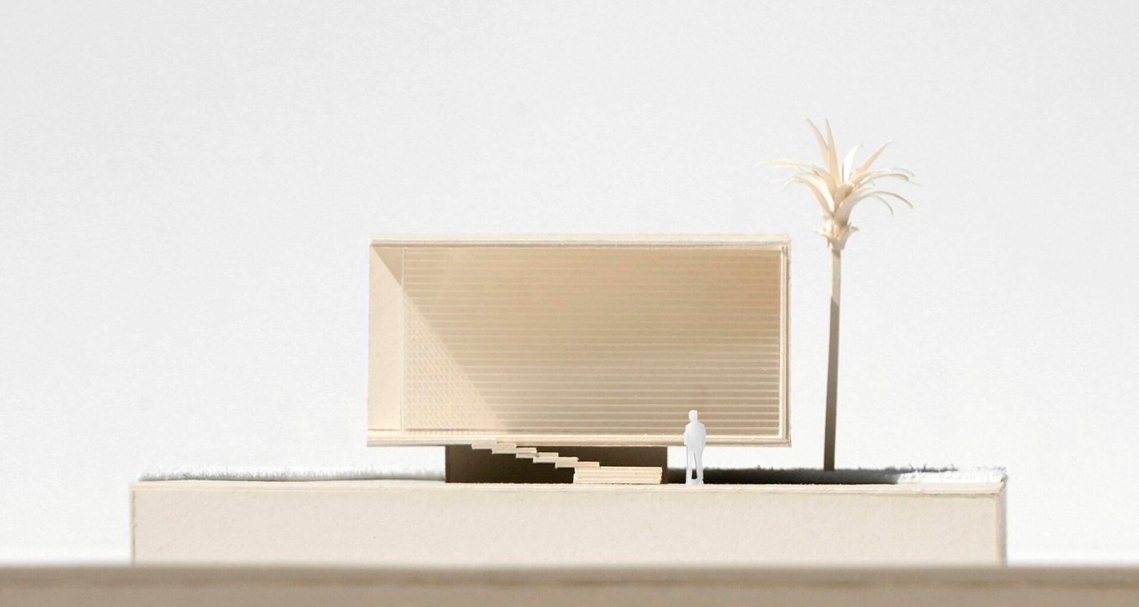 Modell eines modernen Gebäudes mit einer Palme im Vordergrund, ideal für Themen zu Architektur und Bauplanung