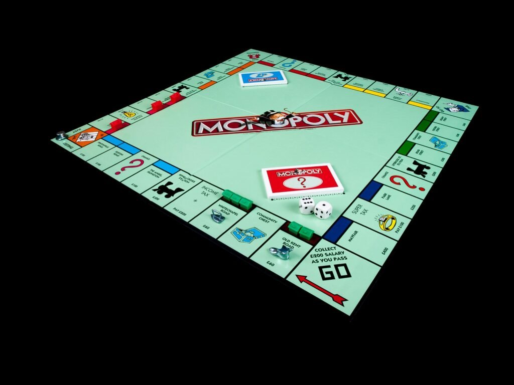 Monopoly-Brettspiel mit Spielfiguren und Karten auf schwarzem Hintergrund, symbolisch für Strategie und Wirtschaft
