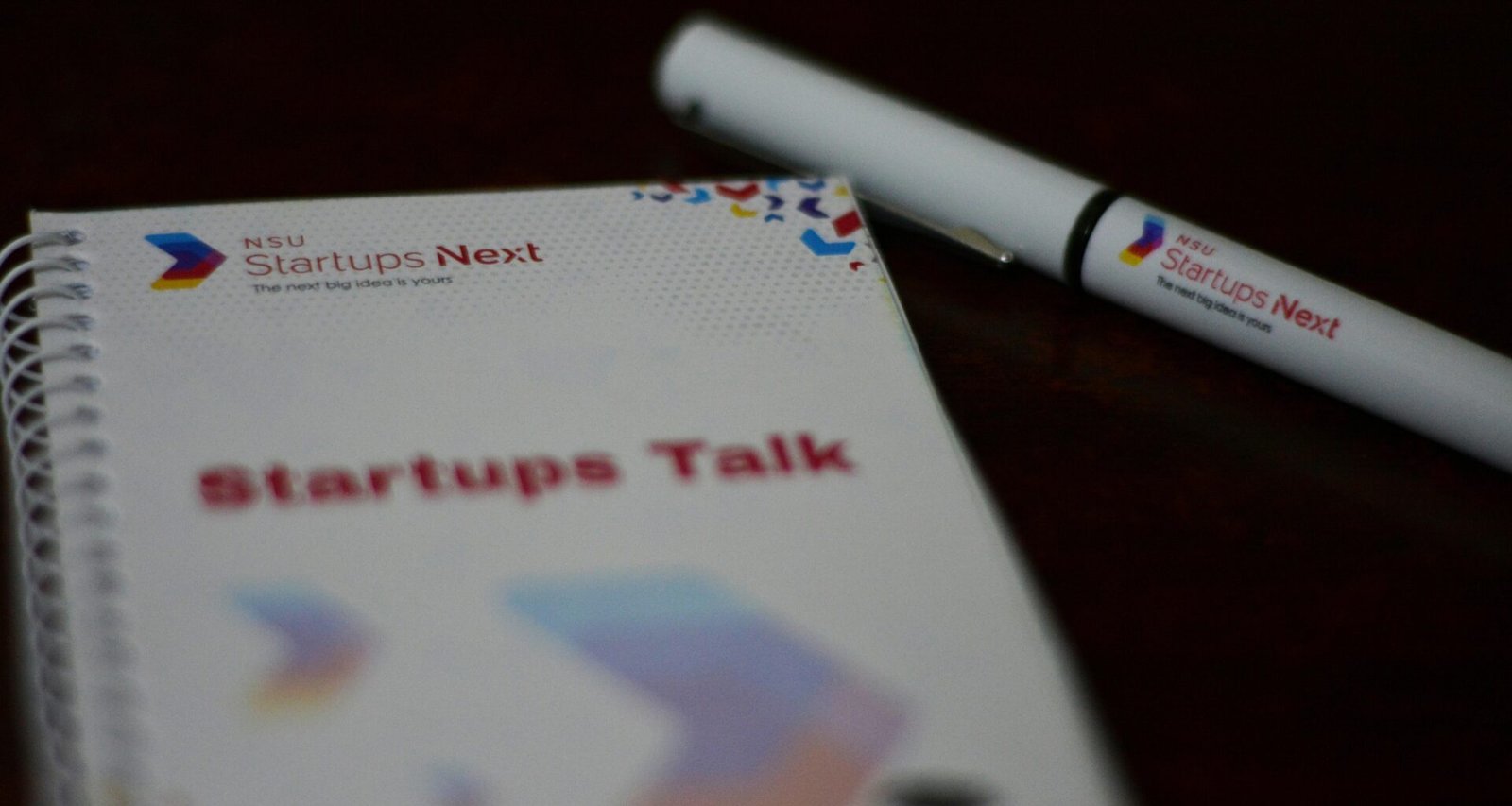 Ein Notizbuch mit einem aufliegenden Stift auf einem Tisch, bereit für Notizen oder schriftliche Gedanken.