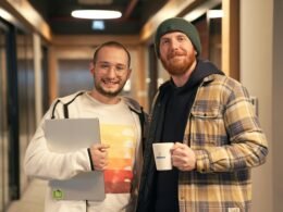 Zwei Männer stehen nebeneinander, Fokus auf Teamarbeit und Kooperation in einem modernen Umfeld