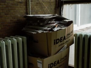 Kartonbox auf einem weißen Heizkörper platziert, neutraler Hintergrund, geeignet für Artikel zu Versand oder Lagerung