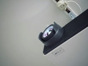 Ein zeitgemäßer Projektor positioniert auf einer weißen Wand, optimal für professionelle Präsentationen und Events.