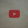 Roter Play-Button liegt auf einem weißen Stück Papier und steht als Symbol für Video-Inhalte auf Websites.