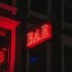 Rotes, beleuchtetes Bar-Schild leuchtet in der Dunkelheit, fotografiert von Jose Marroquin – urbanes Nachtbild