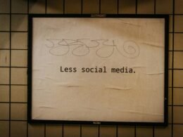 Ein an einer Wand angebrachtes Schild mit der Aufschrift 'less social media'; spricht Online-Verhalten an