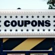 Ein Schild mit der Aufschrift 'Coupons', aufgenommen aus nächster Nähe, als Symbol für digitale Rabattaktionen.