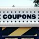 Ein Schild mit der Aufschrift 'Coupons', aufgenommen aus nächster Nähe, als Symbol für digitale Rabattaktionen.