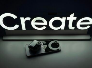 Schwarz-weißes Foto einer professionellen Kamera neben einem Schild auf einer ebenen Fläche