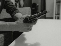 Schwarz-weiß Foto einer Person, die ein Smartphone in der Hand hält, im Fokus steht das moderne Mobiltelefon