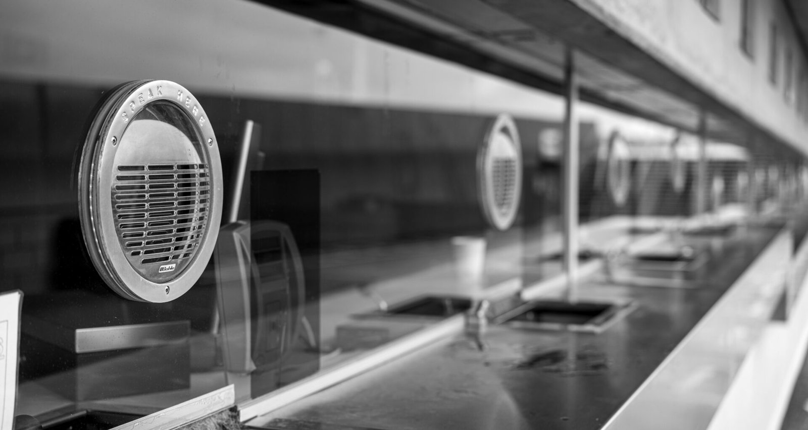 Schwarz-weiß Fotografie einer Reihe von Waschbecken in moderner Ausführung, ideal als Motiv für Themen zu Design oder Hygiene.