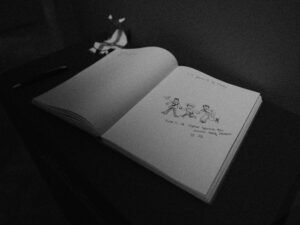 Schwarz-weißes Foto eines aufgeschlagenen Buches auf einer Oberfläche, ideal für Artikel über Literatur, Wissen oder Bildung