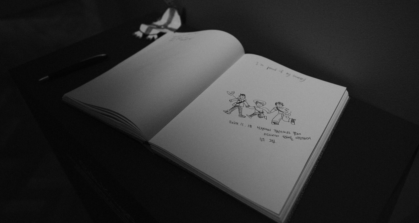 Schwarzweißaufnahme eines aufgeschlagenen Buchs, das auf einer flachen Oberfläche liegt, für Artikel über Lesen oder Bildung