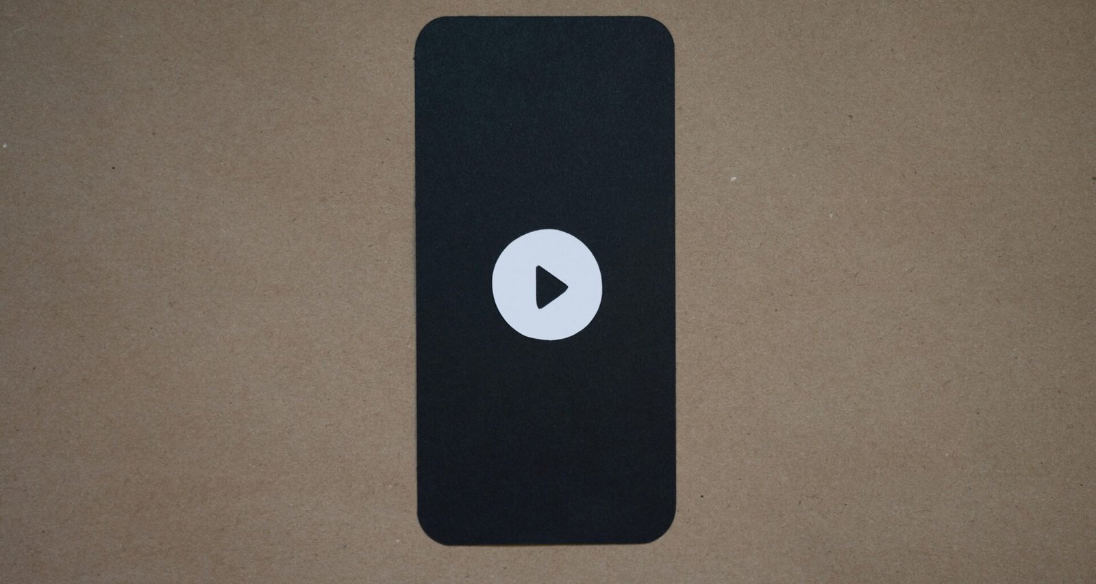 Schwarzes technisches Gerät mit hervorgehobenem Play-Button auf der Oberfläche, geeignet für digitale Medienartikel