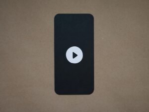 Schwarzes elektronisches Gerät mit deutlich sichtbarem Play-Button, ideal für Themen zu Medien und Technik