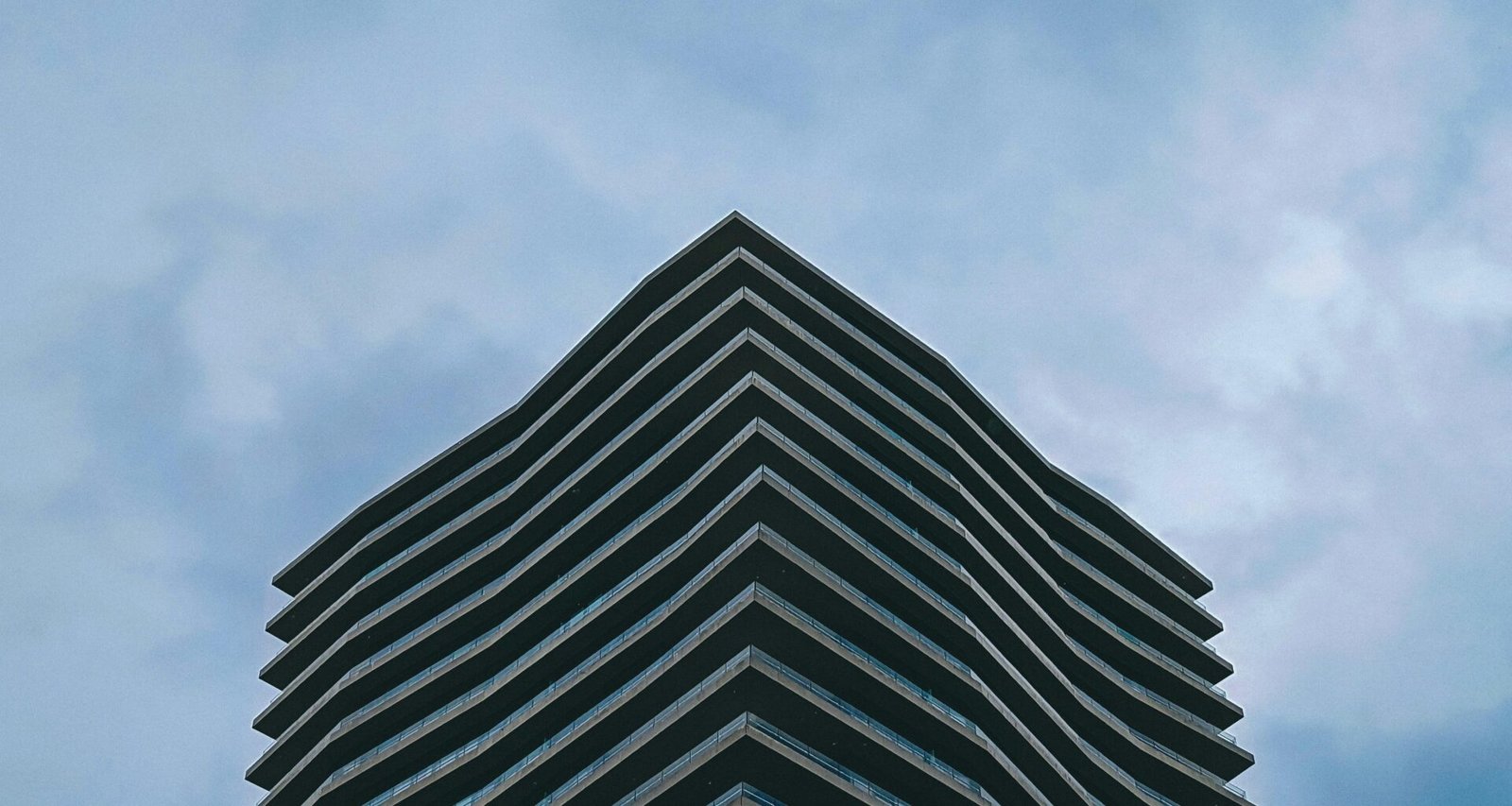 Sehr hohes Gebäude mit klarer Himmelskulisse, aufgenommen aus der Froschperspektive, passend zum Thema Architektur