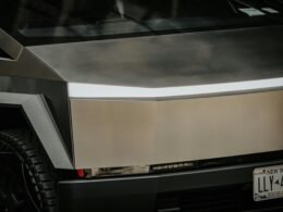 Silbernes Fahrzeug geparkt vor einem modernen Gebäude, geeignet für Themen zu Architektur oder städtischer Mobilität