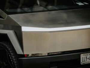 Silbernes Fahrzeug geparkt vor einem modernen Gebäude, geeignet für Themen zu Architektur oder städtischer Mobilität