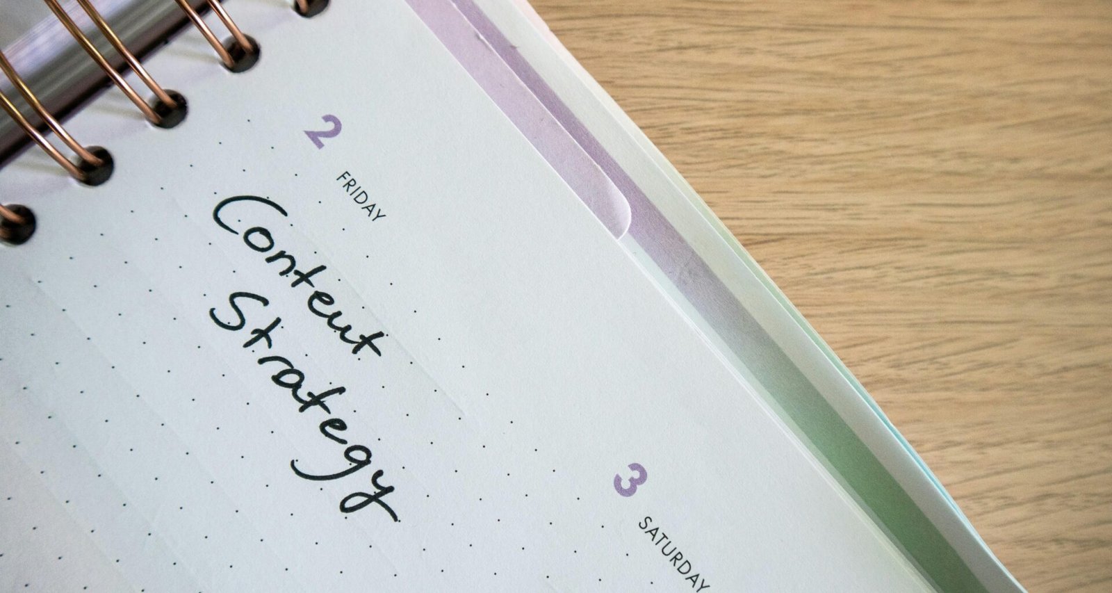 Ein aufgeklappter Spiralblock mit Notizblock und Kugelschreiber liegt ordentlich auf einem Tisch, bereit für Notizen.