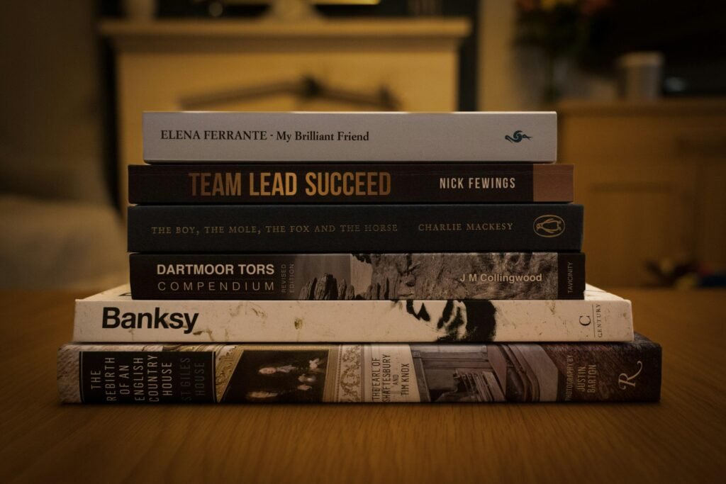 Ein Stapel verschiedener Bücher liegt übereinander auf einer Oberfläche – Symbolbild für Wissen und Weiterbildung.