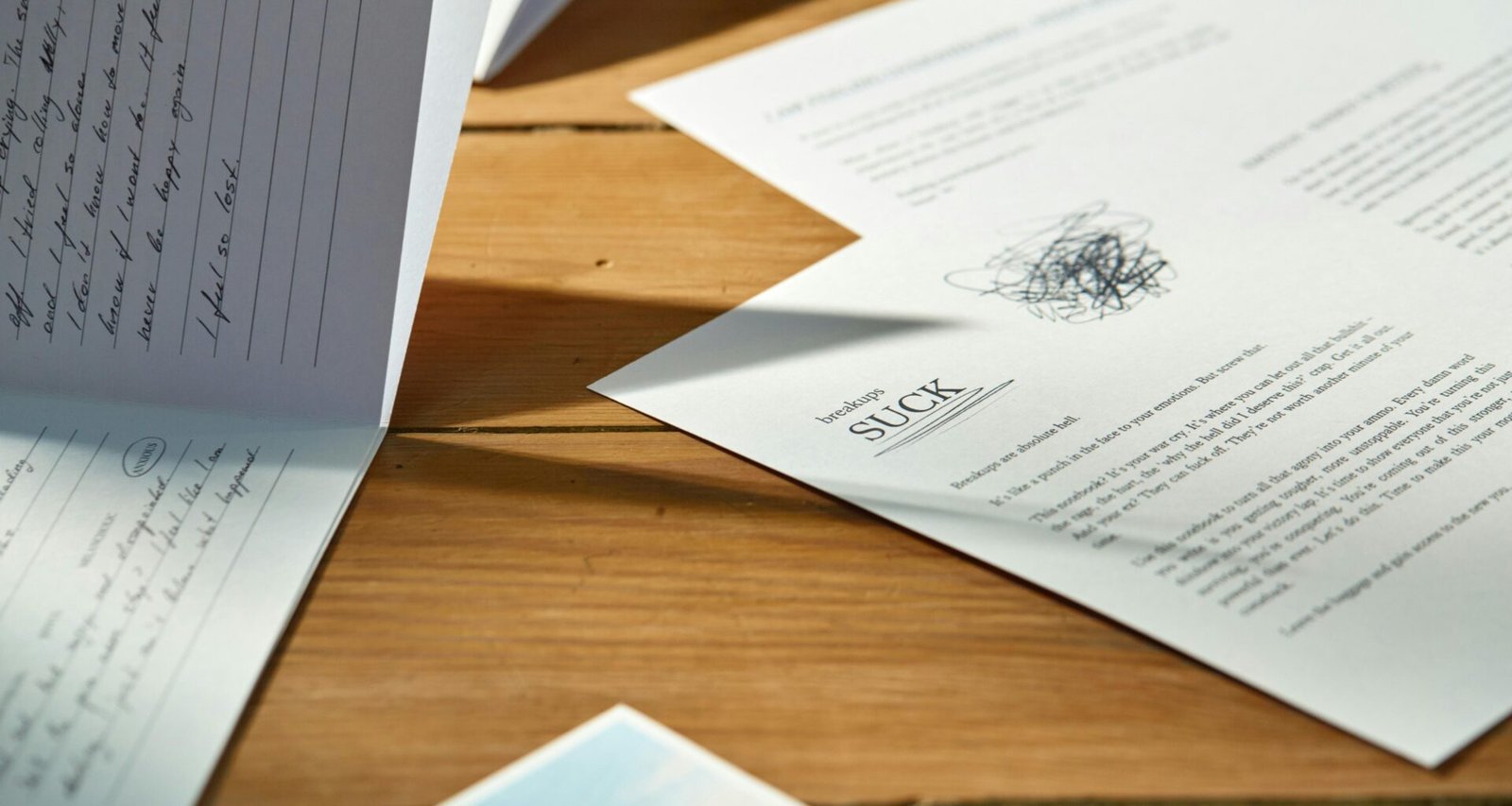 Ein Stapel Papiere liegt auf einem hellen Holztisch, im Fokus steht die Arbeitsorganisation im Büro.