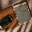 Tablet-Computer und Geldbörse liegen nebeneinander auf einem Tisch. Das Bild zeigt einen typischen Technik-Alltag.