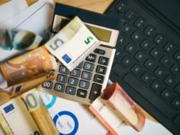 Ein Taschenrechner liegt auf einer größeren Menge von Euro-Geldscheinen und steht für Finanzberechnungen und Budgetplanung.