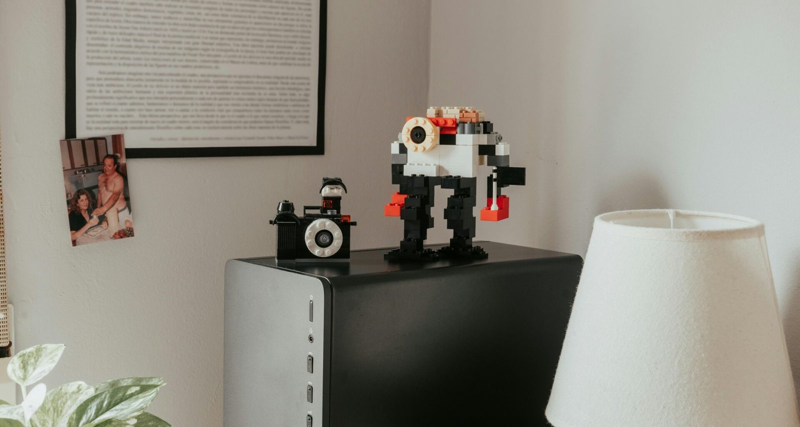 Ein Tisch mit einer modernen Schreibtischlampe und Legosteinen darauf, ideal für kreative Arbeitsumgebungen oder Homeoffice.