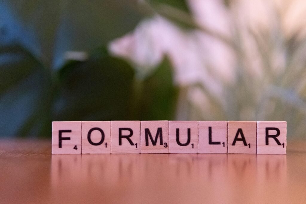 Scrabble-Steine auf einem Holztisch bilden das Wort Formel, Symbol für Strategie und Planung im Online-Marketing