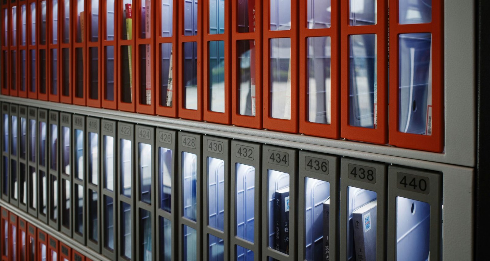 Eine Gebäudefassade mit einer Wand aus Fenstern, die von auffälligen roten Rahmen eingefasst werden.