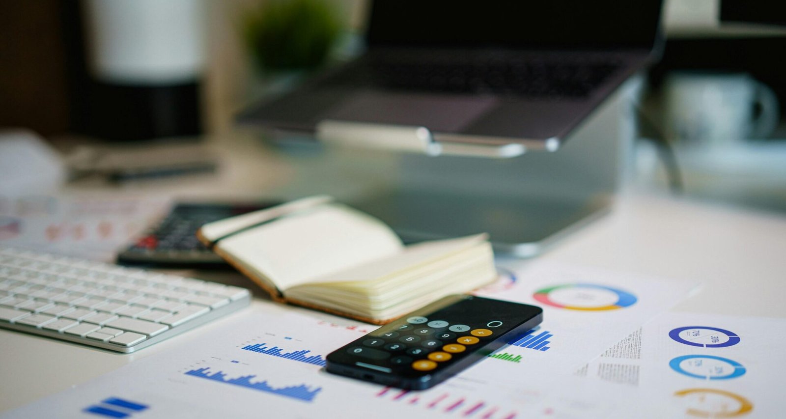 Fernbedienung auf einem Tisch neben einem aufgeklappten Buch, Fokus auf technische Gegenstände im Arbeitsumfeld.