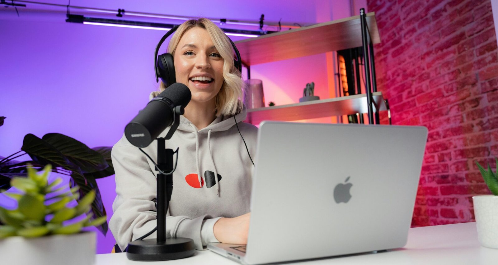 Eine Frau sitzt an einem Tisch vor einem Laptop und arbeitet in einem modernen Raum mit schlichter Einrichtung