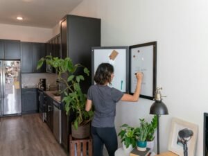 Eine Frau steht in einer modernen Küche vor einem geöffneten Kühlschrank, Fokus auf Küchentechnologie