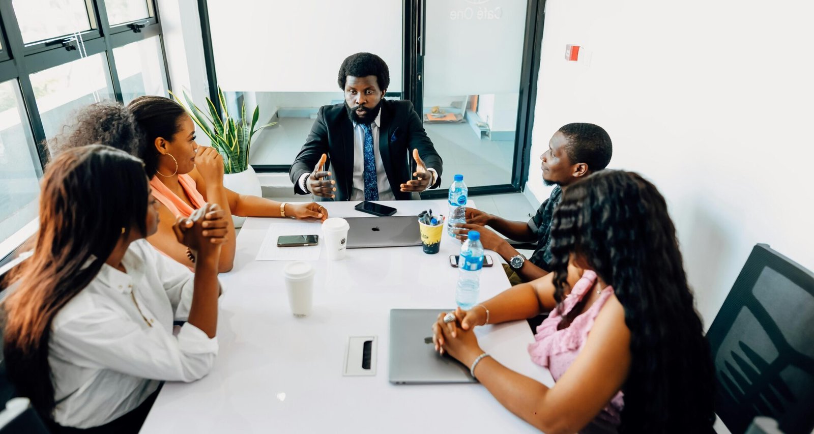 Mehrere Personen sitzen um einen weißen Tisch und besprechen gemeinsam Ideen während eines Meetings im Büro.
