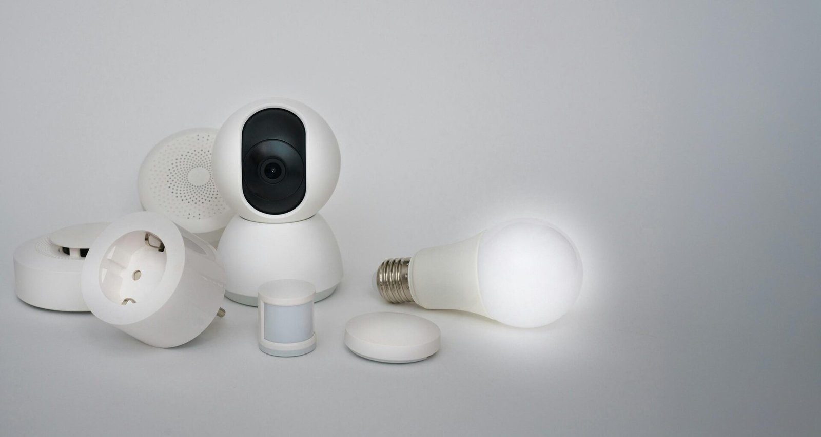 Mehrere weiße Alltagsgegenstände, arrangiert auf einer ebenen Tischoberfläche und aus der Vogelperspektive fotografiert.