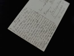 Nahaufnahme eines Blattes Papier mit handschriftlichen Notizen, Fokus auf die Schrift und das Papiermaterial