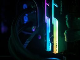 Nahaufnahme eines Computers und verwickelter Kabel in einem abgedunkelten Technikraum