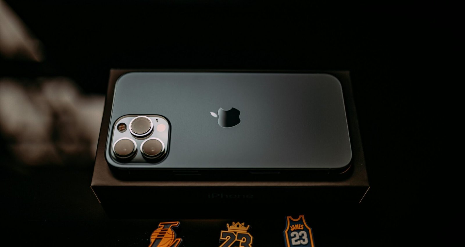 Nahaufnahme eines modernen Smartphones, das in einer weißen Verpackungsschachtel liegt und für den Verkauf vorbereitet ist.