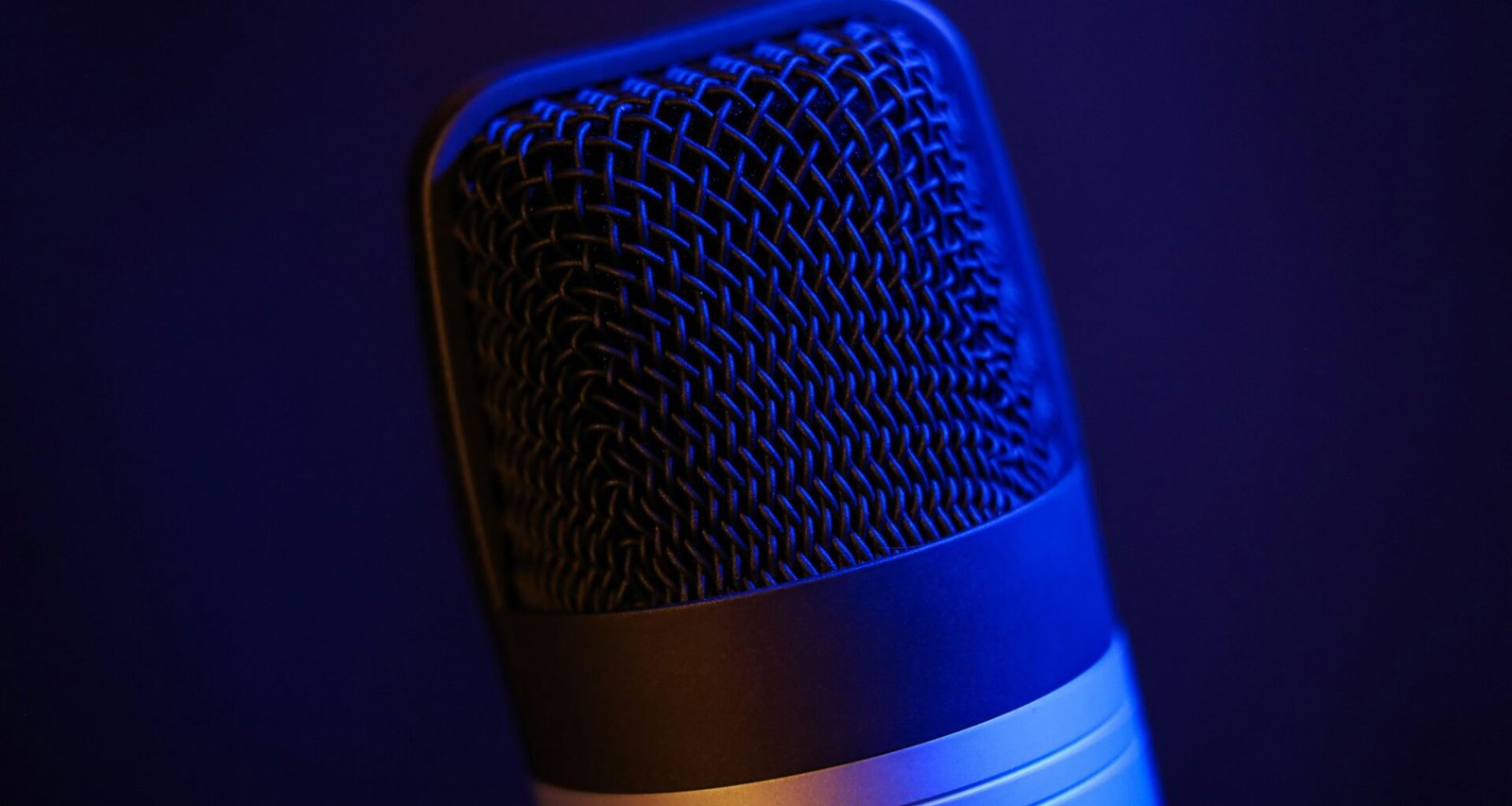 Detailaufnahme eines Mikrofons in einem dunklen Raum, passend zu Themen wie Podcast, Audio-Technik und digitale Medien