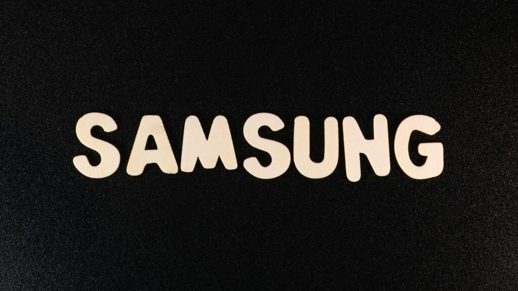 Nahaufnahme des Samsung Logos auf einer schwarzen Oberfläche, ideal für Beiträge zu Technik oder Marken im digitalen Umfeld.